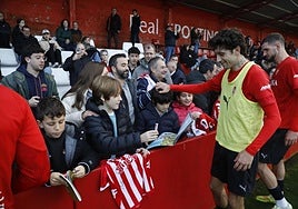 César Gelabert y Justin Smith saludan a algunos de los aficionados sportinguistas que se acercaron a Mareo para ver de cerca el entrenamiento.