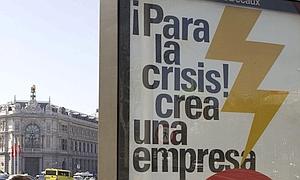 Un cartel publicitario con referencia a la crisis de la economía española, junto a la sede del Banco de España, en Madrid. / Ap