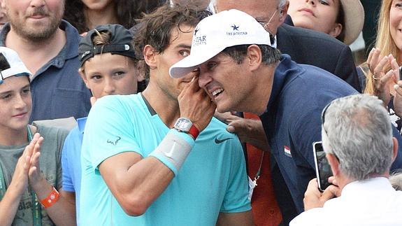 Rafael Nadal (i) habla con su tío al final del partido. 