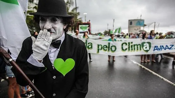 Un hombre vestido como el personaje de Charles Chaplin participa en la playa de Ipanema, durante la marcha contra contra el cambio climático