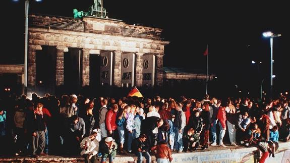 Miles de personas festejan encima del Muro la apertura de fronteras de la RDA. 