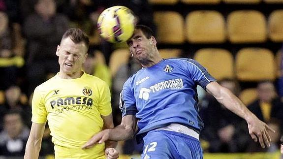 El centrocampista ruso del Villarreal Denis Cheryshev (i) salta por el balón con Álvaro Arroyo, defensa del Getafe 