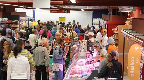 Personas haciendo la compra en un supermercado. 