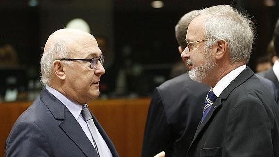 El presidente del BEI, Werner Hoyer, a la derecha, habla con el ministro francés de Finanzas Michel Sapin. 