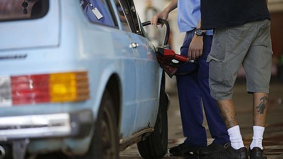 Un hombre cha gasolina en su vehículo. 