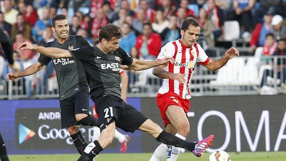 Ivanschitz (i) disputa un balón con Verza (d).  