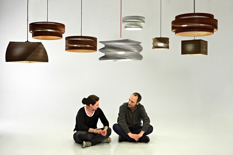 Los dos impulsores de Lámparas de Cartón, junto a algunas de sus creaciones. 