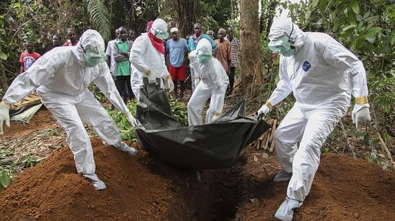 Enfermeros liberianos trasladan el cuerpo de una víctima del virus Ébola hasta un sitio para enterrarlo.