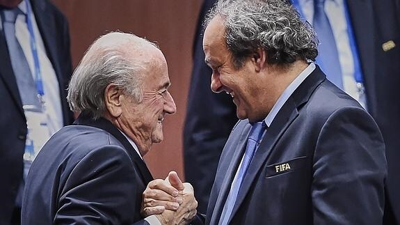 Blatter (i) y Platini se saludan. 