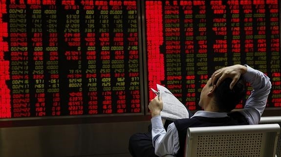 Inversores observan la información bursátil en una correduría en Pekín. 