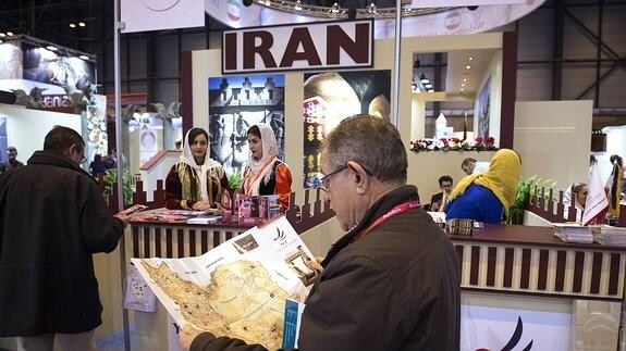 Varios visitantes se interesan por el 'stand' de Irán en Fitur.