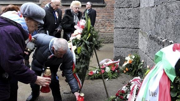 Exprisioneros depositan velas y flores ante el Muro de la Muerte en el campo de concentración y exterminio nazi de Auschwitz-Birkenau durante los actos del 71º aniversario de la liberación.