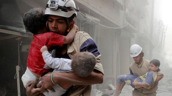 Voluntarios trasladan a niños heridos tras un bombardeo sobre Alepo.
