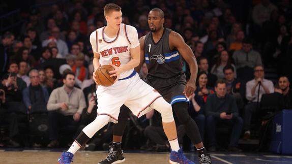 Kristaps Porzingis trata de zafarse de Ibaka (derecha).