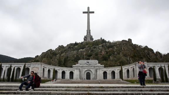 Varios visitantes se fotografían ante el Valle de los Caídos.
