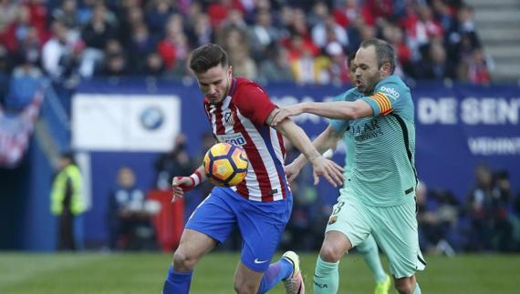 Iniesta disputa un balón con Saúl en el Calderón. 
