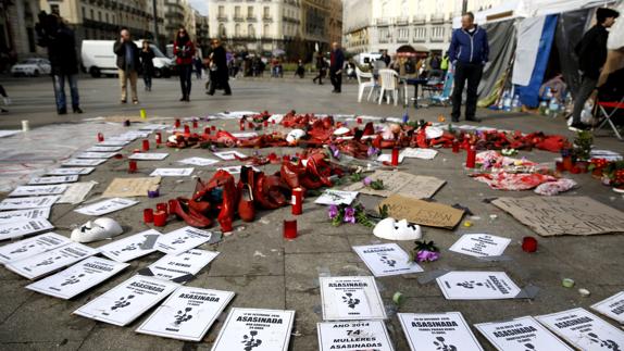 Detalle de las flores, zapatos y carteles en la acampada contra la violencia machista en la Puerta del Sol.