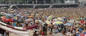 SAN LORENZO. Aspecto de la playa gijonesa ayer por la tarde, con multitud de personas que aprovecharon el buen tiempo para disfrutar del mar en las horas previas al lanzamiento de la pirotecnia. / UCHA