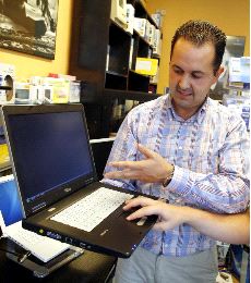 AYUDAS. Un cliente observa las prestaciones de un portatil en un comercio. / MARCOS VEGA