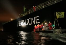 Activistas de Greenpeace pintan en el barco la frase 'Abandonemos el carbón'. / AFP