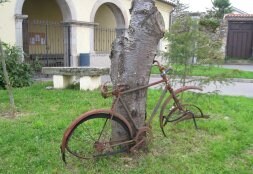 El viejo medio de transporte está apoyado en un árbol frente a la iglesia del pueblo. / E. V.