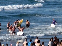 Los surfistas salen del agua con los jóvenes ante la mirada de los curiosos. / LVA