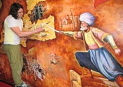 El artista Iván Jambrina repasa el mural. A la derecha de la obra, puede observarse la recreación de Barbarroja. ::                             I. GÓMEZ