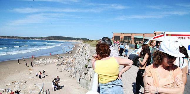 Un grupo de personas sigue desde el paseo el rescate del domingo :: 