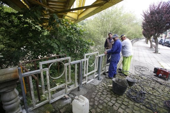 Operarios municipales, el pasado jueves, reparan la valla ubicada en la zona del paseo en la que se cayó un matrimonio de invidentes. 