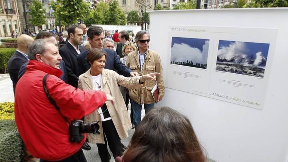 El fotógrafo Juan Carlos Tuero explica a la alcaldesa parte de la exposición, en presencia, entre otros, del concejal Felgueroso.