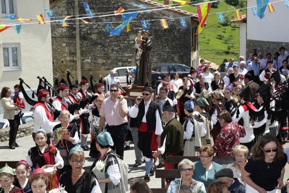 La imagen de San Antonio, flanqueada por las aldeanas y la banda de gaitas, en la procesión. 