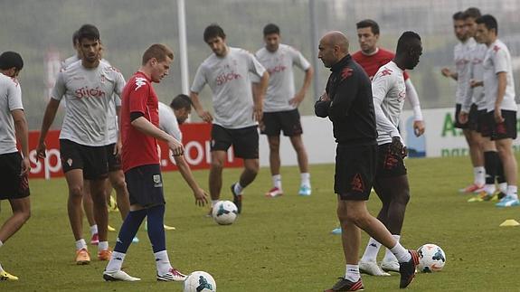 Los futbolistas y el técnico, entrenando.