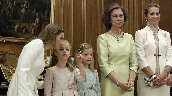 La Reina escucha a la Princesa de Asturias.