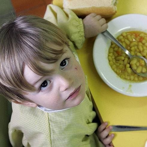 Un niño, en un comedor escolar. 