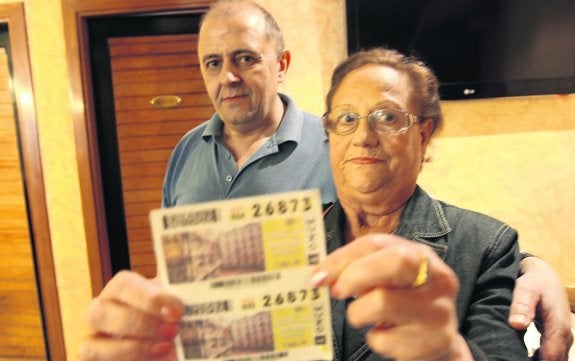 Araceli Pidal mostrando ayer dos cupones premiados, junto a Luis Arce, en el Vaporetto. 