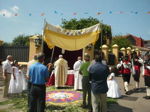 La procesión, junto al altar y la alfombra floral en La Nozalera. :: E. C.