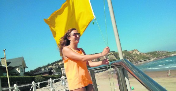 Una socorrista iza a las once y media de la mañana de ayer la bandera amarilla en la playa de Salinas a la altura del puesto principal. Se mantuvo todo el día. 