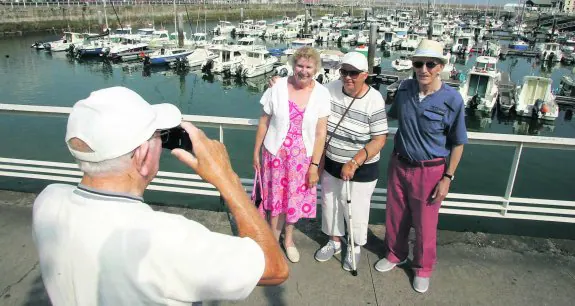 Betty, Christine Berret y Rory, posando en el Puerto Deportivo. Abajo, el barco, atracado. 