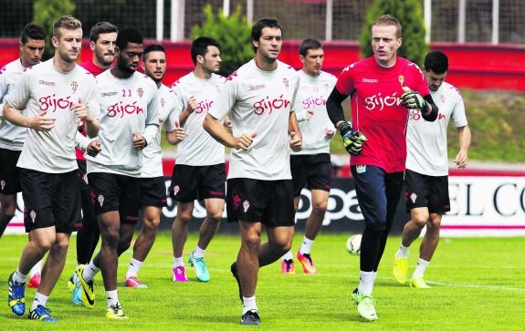 El guardameta Alberto García, ayer, delante de varios futbolistas del Sporting durante el entrenamiento matinal. 