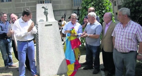 El alcalde de Tineo, José Ramón Feito (izquierda), Manolo García Linares, Belarmino Fernández, Ramón García, Florentino Martínez Roces y Bertino Velasco tras descubrir la placa de Bueño en el monolito. 