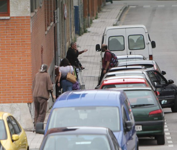 Un grupo de usuarios a la espera de poder entrar en el centro de día del Albergue Covadonga. 