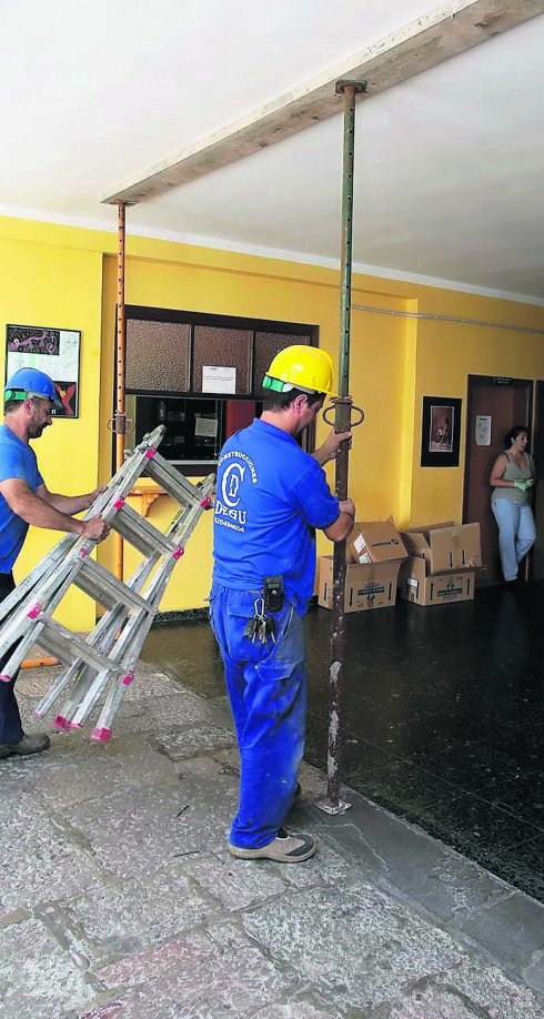 Varios operarios en el interior del edificio afectado del instituto. 