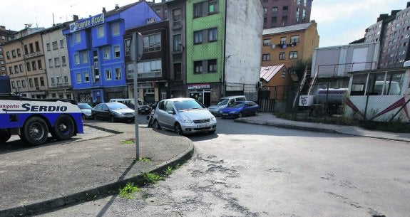 Pese al colorido de algunos edificios, la sensación de abandono de la calle Acero queda patente a la vista del estado del asfalto y de la maleza que crece en las aceras. 