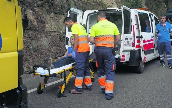 La mujer herida es introducida en la ambulancia para su traslado al hospital de Arriondas. 