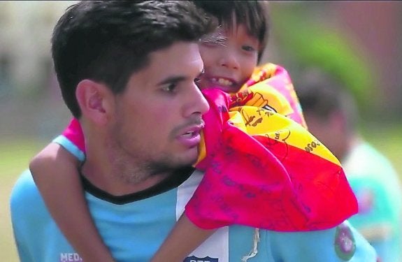 Pablo Argüelles sostiene a un niño filipino sobre sus hombros. 