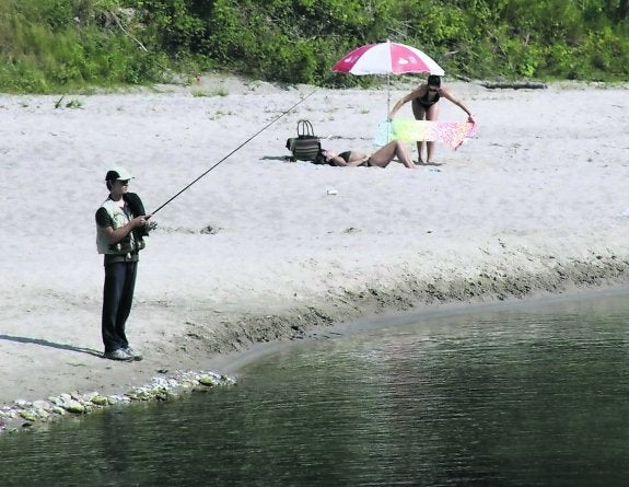 Un pescador apostado en una de las orillas del río Cares-Deva. 