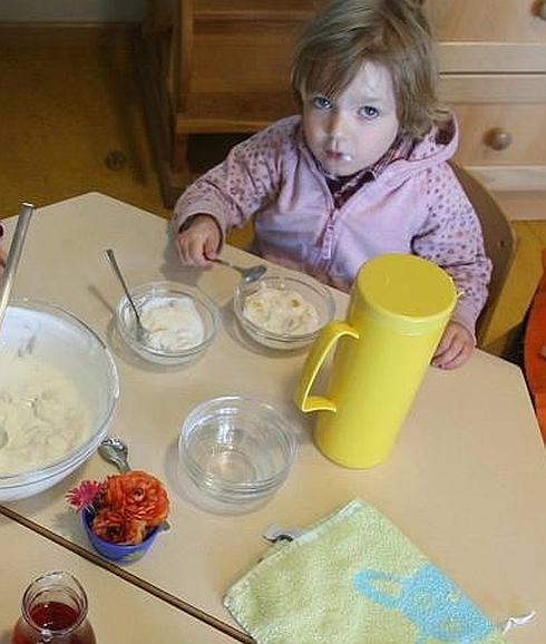 Una niña comiendo en un comedor escolar. 