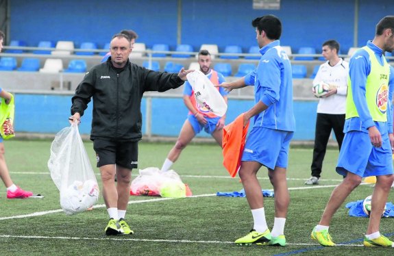 Josu Uribe reparte petos entre sus futbolistas en el sintético de Santo Domingo. 