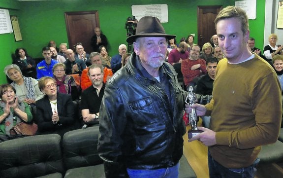 Edgar Plans, hijo del homenajeado, recoge el premio de manos de Faustino Rodríguez Arbesú. 