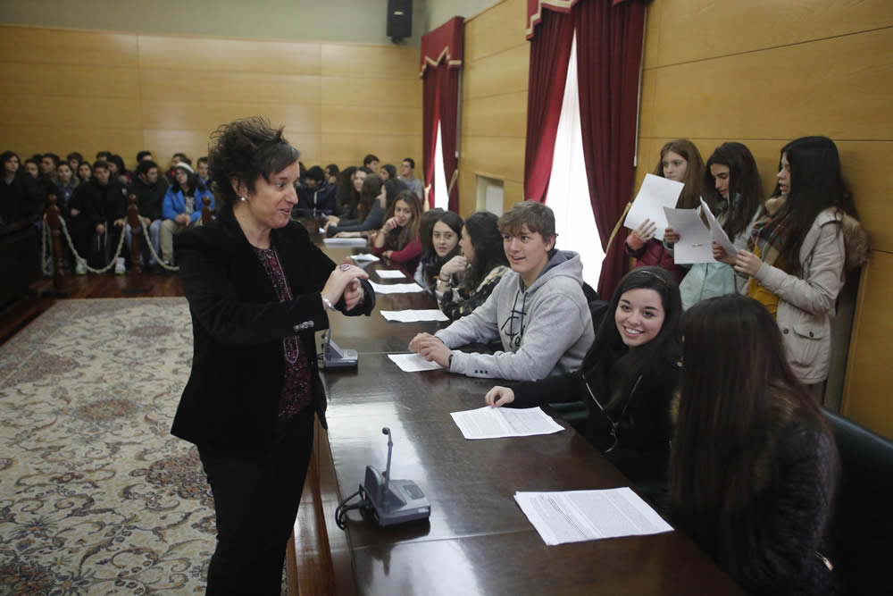 Los alumnos, en el salón de plenos municipal, junto a la alcaldesa, explican sus ideas sobre el racismo. 
